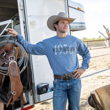 Load image into Gallery viewer, Man in cowboy hat and blue shirt standing next to a trailer with horse equipment
